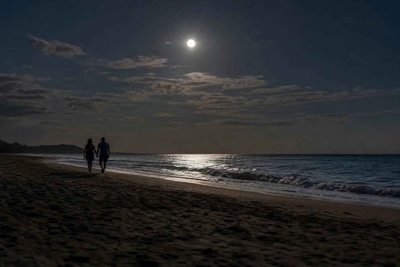 Under the full moon A couple walking on a beach under a full moon