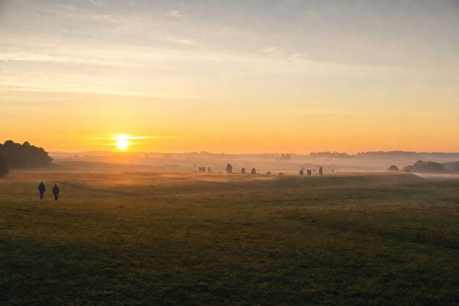 Midsummer sunrise on the plain Midsummer sunrise over a grassy plain with distant standing stones