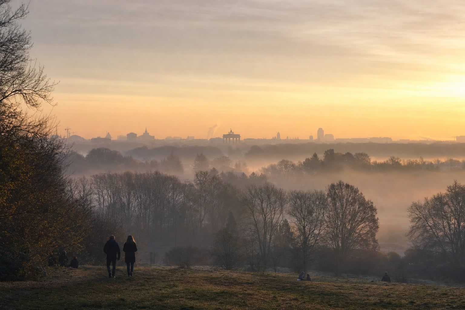 Sunrise over Berlin and the Brandenburg Gate Misty sunrise over the Tiergarten with the Brandenburg Gate far in the distance