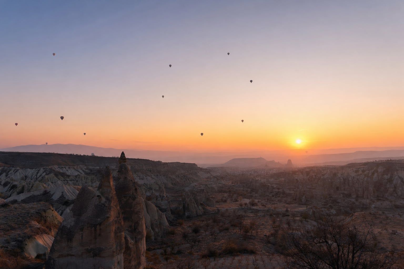 Sunrise over Cappadocia Sunrise over the valleys of Cappadocia with distant hot-air balloons