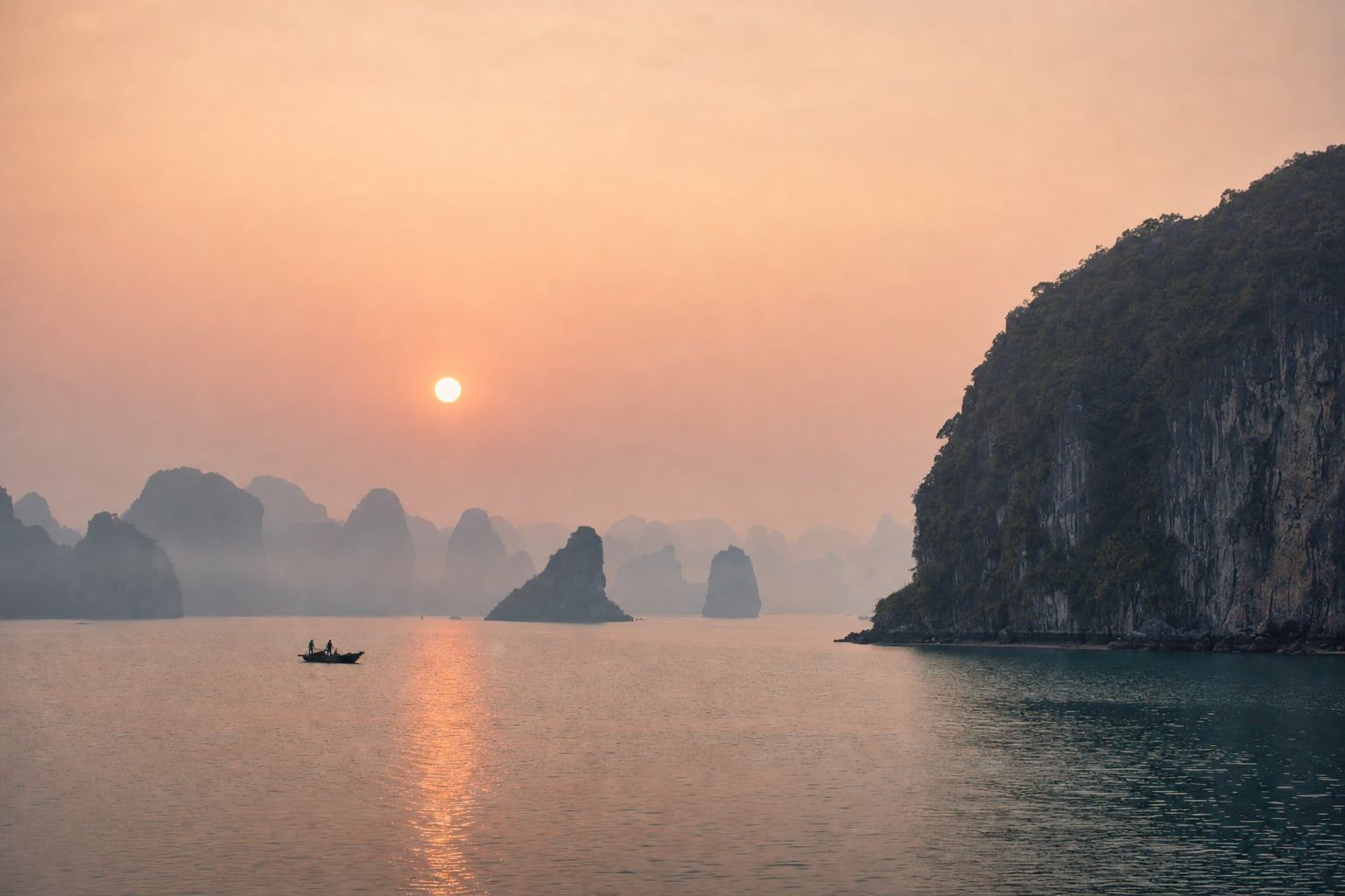 Sunrise over Ha Long Bay Misty sunrise among the limestone islands of Ha Long Bay