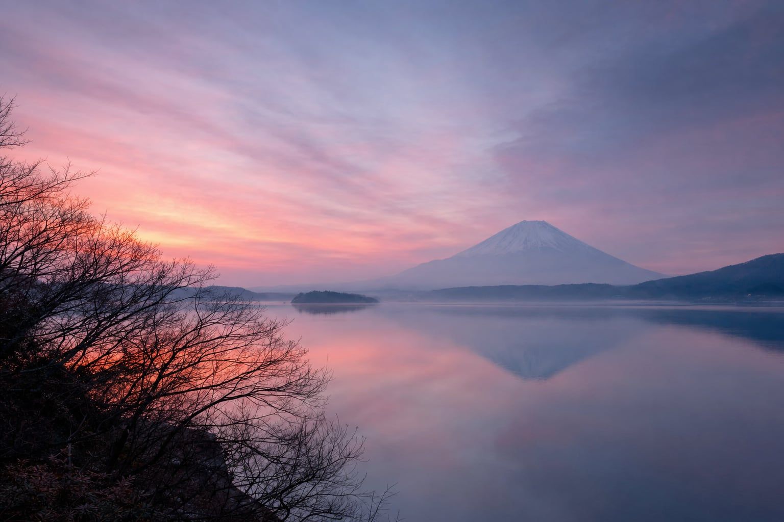 Sunrise over Mount Fuji Pink sunrise over a still lake with Mount Fuji far away