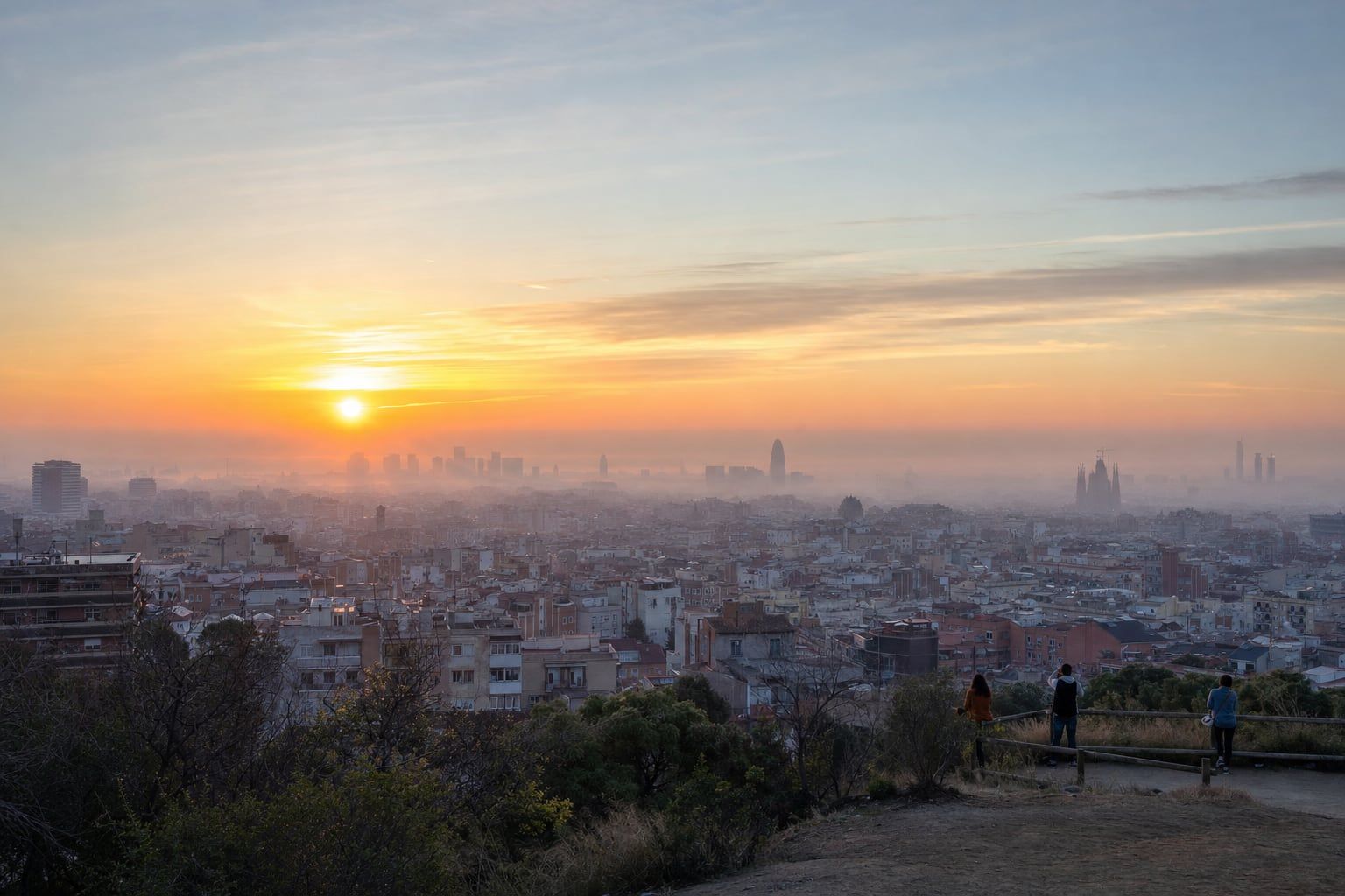 Sunrise over Barcelona and the Sagrada Família Sunrise haze over Barcelona with the Sagrada Família towers far in the distance