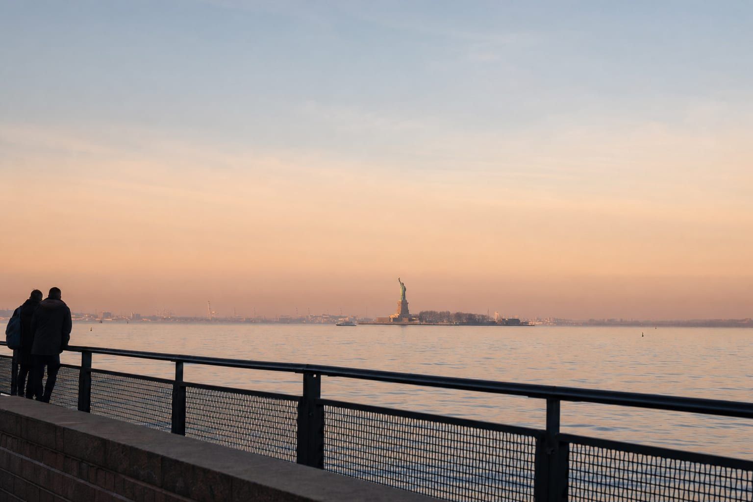 Sunrise over New York Harbor Warm sunrise light on the Statue of Liberty across New York Harbor
