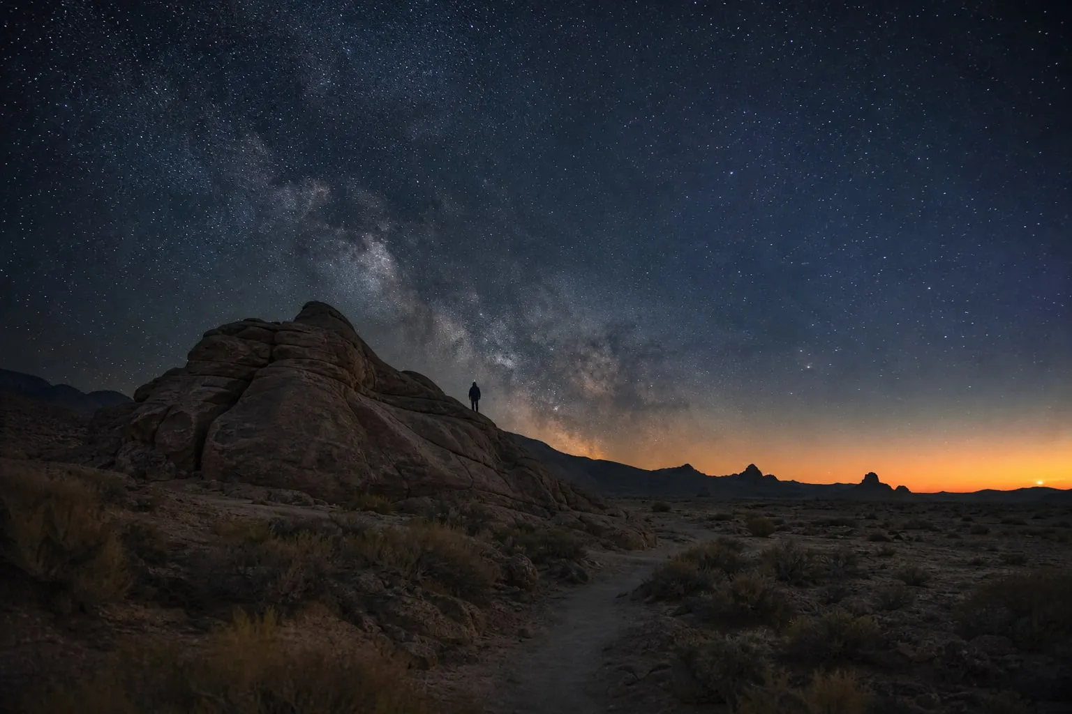 Desert under a darkening starry sky at the end of twilight